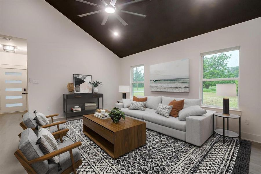 Living room featuring a ceiling fan and high vaulted ceiling