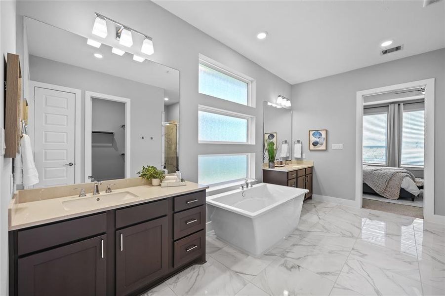 Dual and separate vanities in the primary bathroom