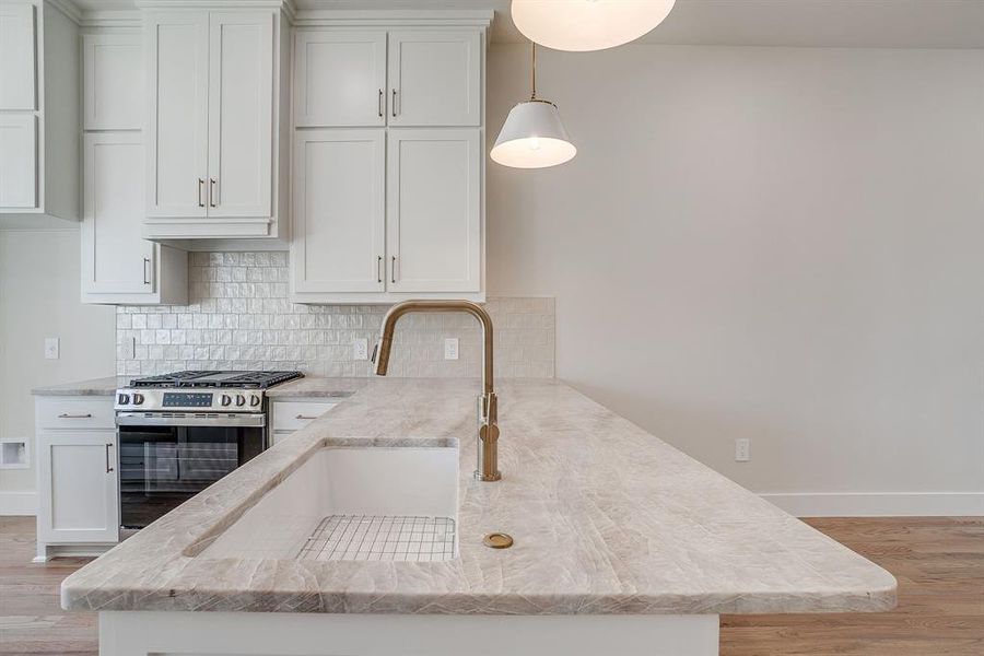 High-end kitchen with real hardwood floors and dramatic stone backsplash. High-end kitchen with real hardwood floors and dramatic stone backsplash.