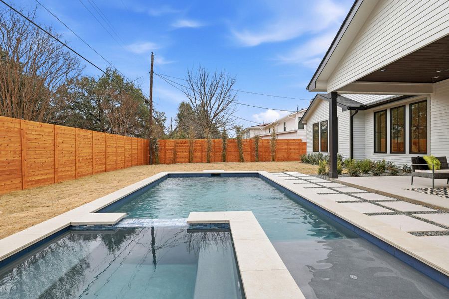 Integrated pool / spa with a patio and a fenced backyard