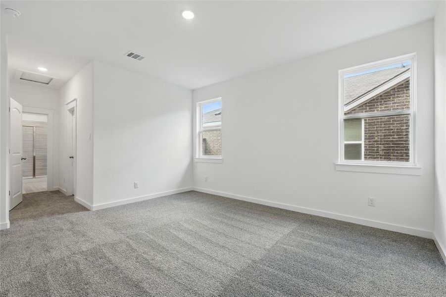 Unfurnished bedroom featuring light colored carpet, attic access, and recessed lighting