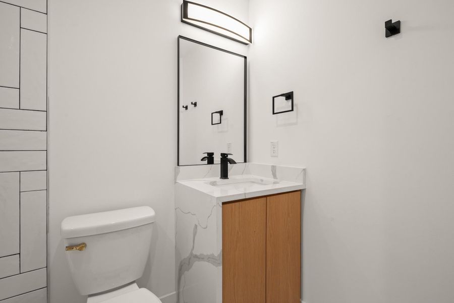 Hall bathroom  with a tub/shower combo featuring vanity and toilet
