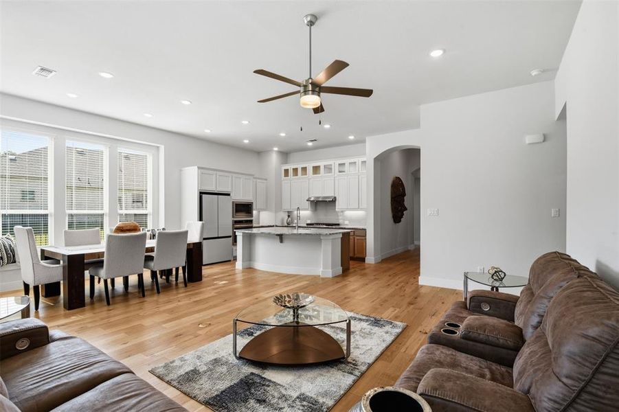 Open-concept living space featuring wood-finish flooring, recessed lighting, and a ceiling fan Open-concept living space featuring wood-finish flooring, recessed lighting, and a ceiling fan