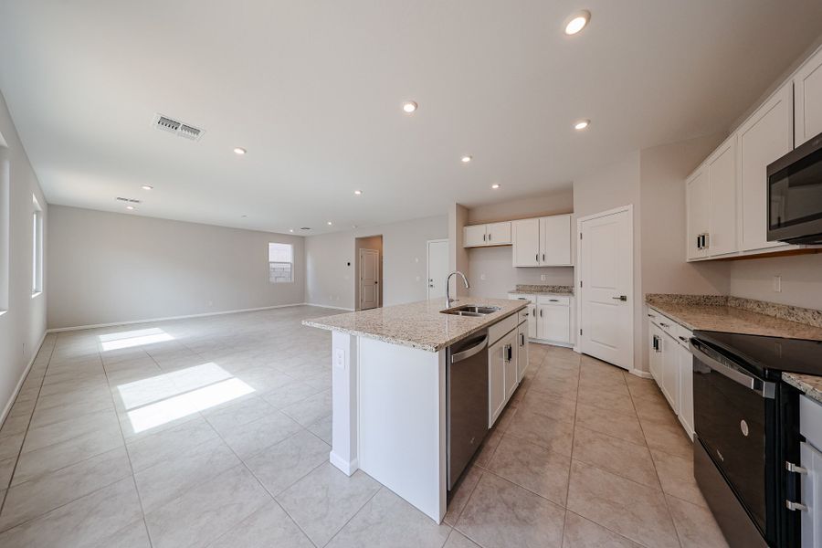 A kitchen with white cabinets.