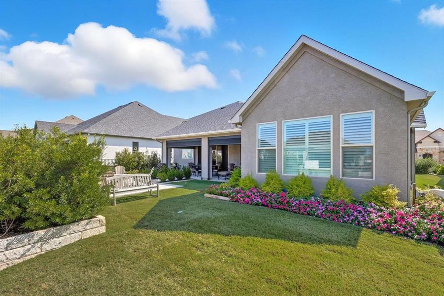 Rear view of house with a lawn, a patio area, and stucco siding