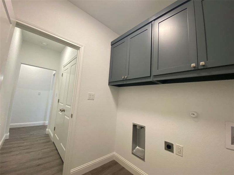 Laundry area with dark wood-style flooring, cabinet space, electric dryer hookup, and washer hookup Laundry area with dark wood-style flooring, cabinet space, electric dryer hookup, and washer hookup