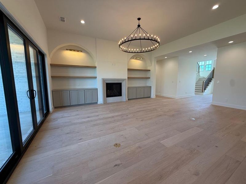 Living Room with gas fireplace, built in cabinetry, accent lighting. Open Concept