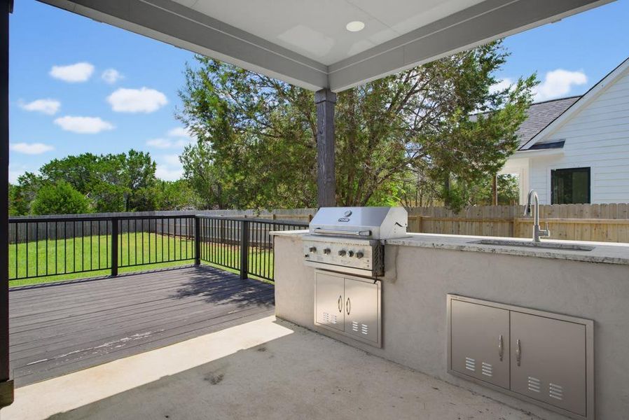 An inviting outdoor kitchen on a spacious deck, perfect for entertaining. An inviting outdoor kitchen on a spacious deck, perfect for entertaining.