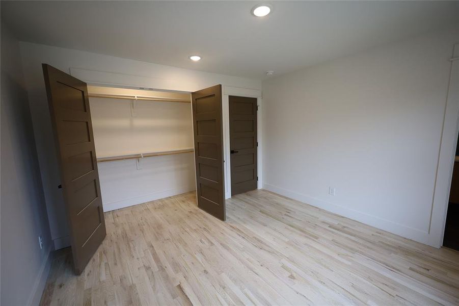 Unfurnished bedroom with light wood finished floors, recessed lighting, and a closet