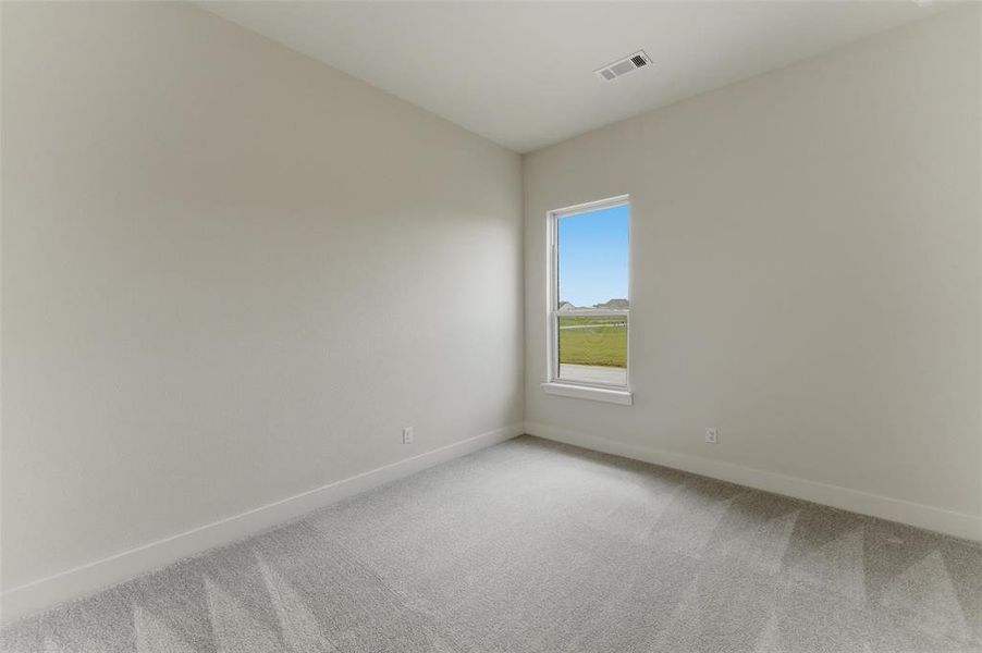 Room featuring neutral tone walls, white trim, light gray carpet flooring, and a single window with white framing