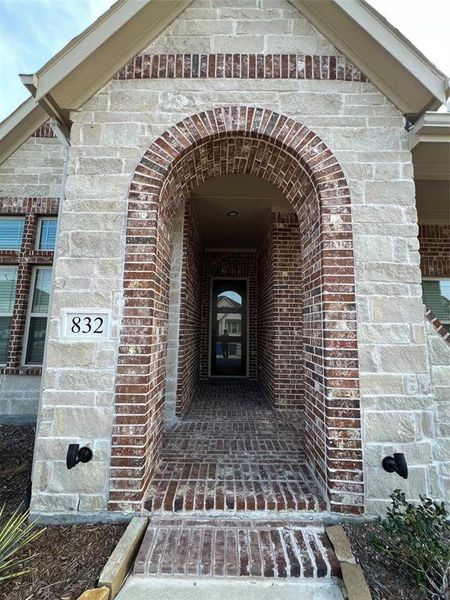 Front porch featuring brick siding and stone facade Front porch featuring brick siding and stone facade