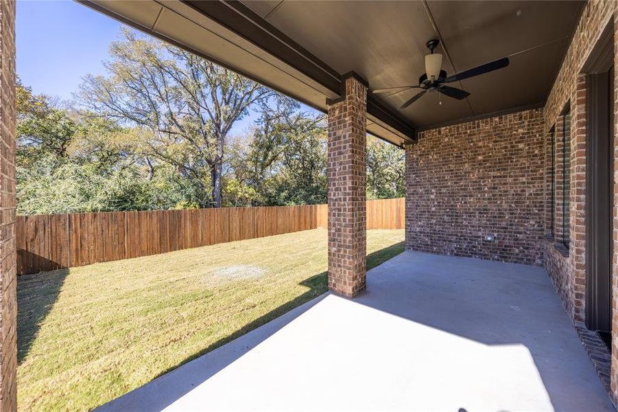 Fenced backyard featuring ceiling fan and a patio