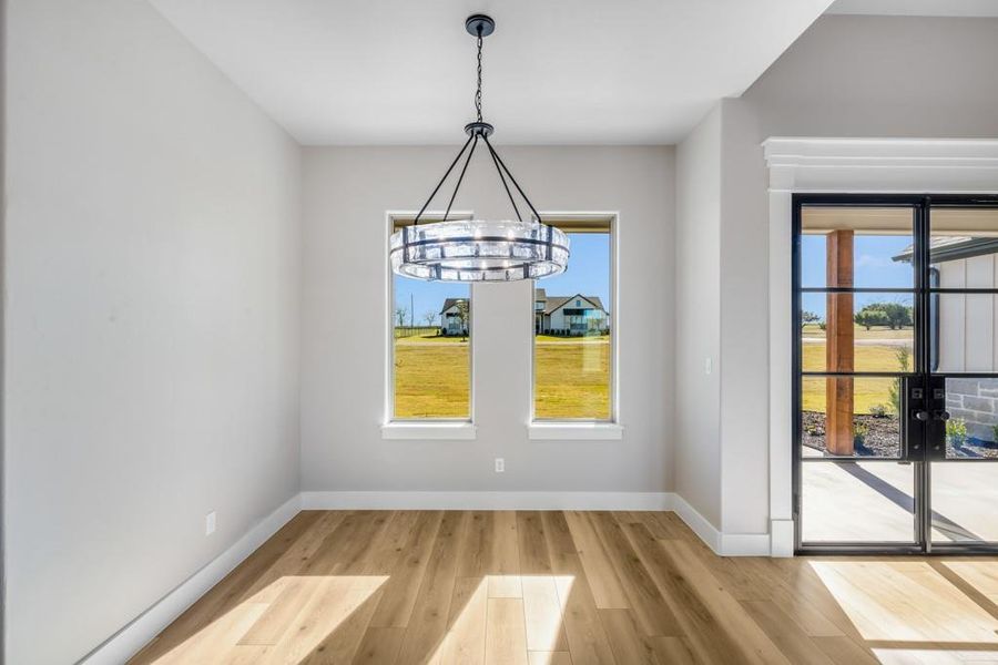 Unfurnished dining area featuring hardwood / wood-style floors and an inviting chandelier