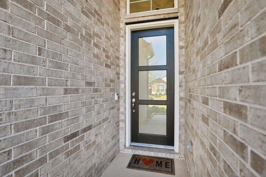 Step into style! The 8-foot modern transitional entry door perfectly complements the light brick elevation, offering an immediate touch of elegance and flooding the interior with natural light. Step into style! The 8-foot modern transitional entry door perfectly complements the light brick elevation, offering an immediate touch of elegance and flooding the interior with natural light.