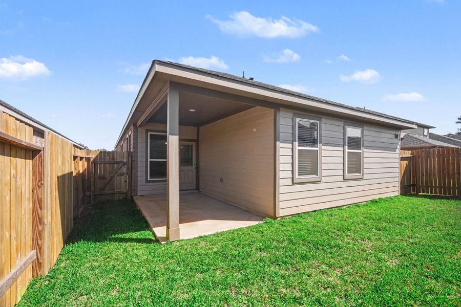 Covered back patio overlooking private yard with plenty of green space Covered back patio overlooking private yard with plenty of green space