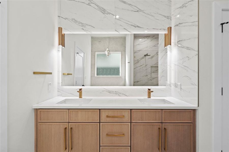 Bathroom with double vanity, a marble finish shower, and a sink