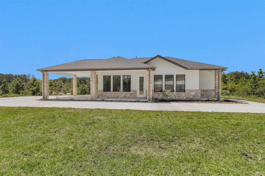 The separate 2-bedroom, 2-bath guest home features a charming stone-accented exterior, full kitchen, carport, and covered porch—perfect for multigenerational living or long-term guests.