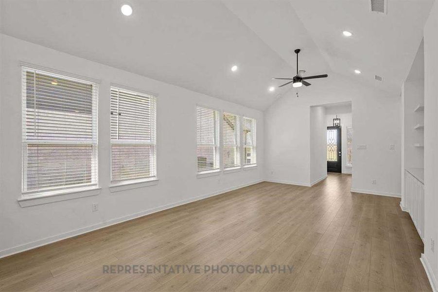 Unfurnished living room with light wood-style floors, lofted ceiling, recessed lighting, and a ceiling fan