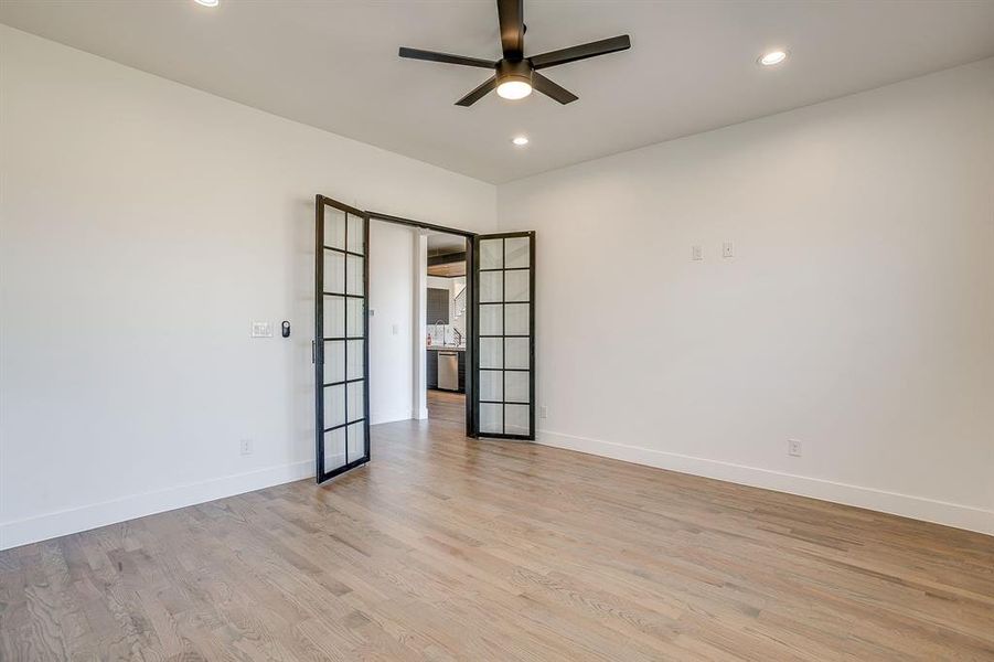 Empty room with light wood-type flooring, recessed lighting, a ceiling fan, and french doors Empty room with light wood-type flooring, recessed lighting, a ceiling fan, and french doors