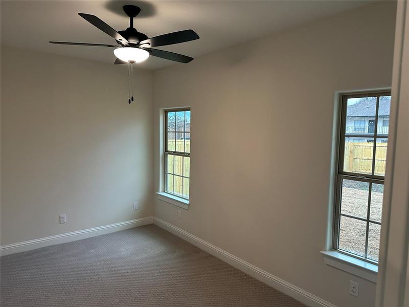 Pimary bedroom with ceiling fan and full-size bathroom with shower.