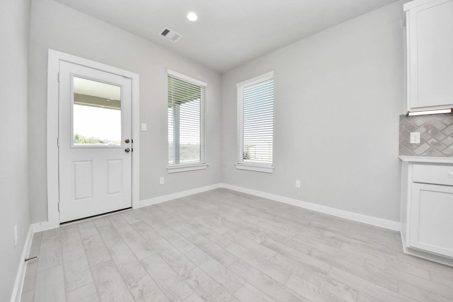 Enjoy breakfast with ease in the connected and cozy breakfast area, seamlessly integrated with the kitchen for utmost convenience. Step through the back door for a breath of fresh air onto the covered patio, extending your living space to the outdoors. Sample photo of completed home with similar floor plan. Actual colors and selections may vary.