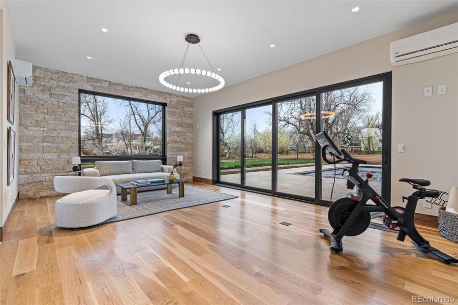 Pool house provides an additional living space or exercise room. Multi-panel sliding glass door opens to the pool/spa & 2,500+ SqFt patio. Includes living area, sauna, steam shower, changing room & water closet. Tech Lighting chandelier.