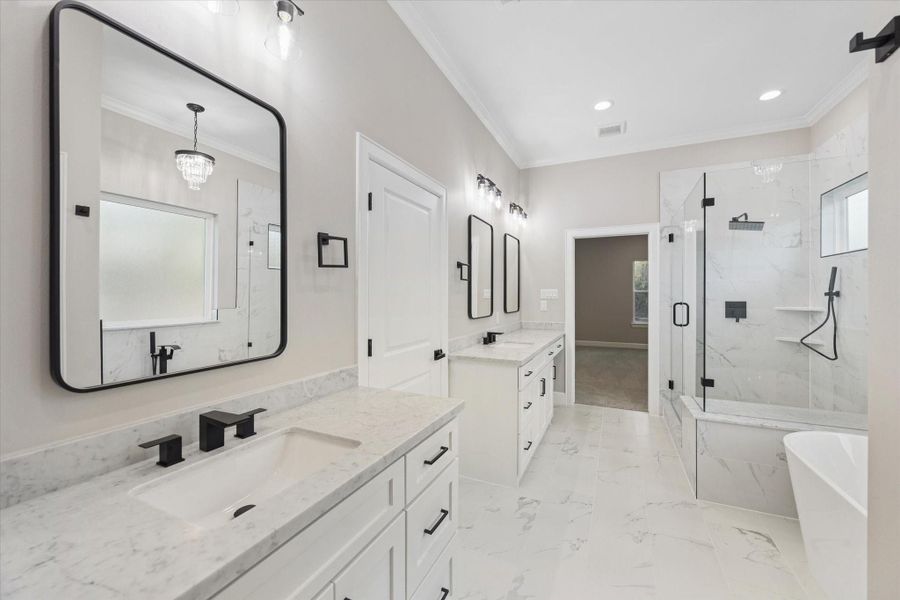 Elegant primary bath with quartz counters and lots of counter space.  Garden tub and beautiful frameless shower.  Rain showerhead and separate hand-held sprayer.