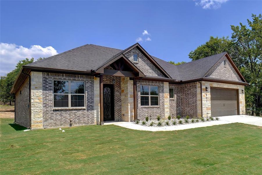 View of front of property featuring a front yard and a garage