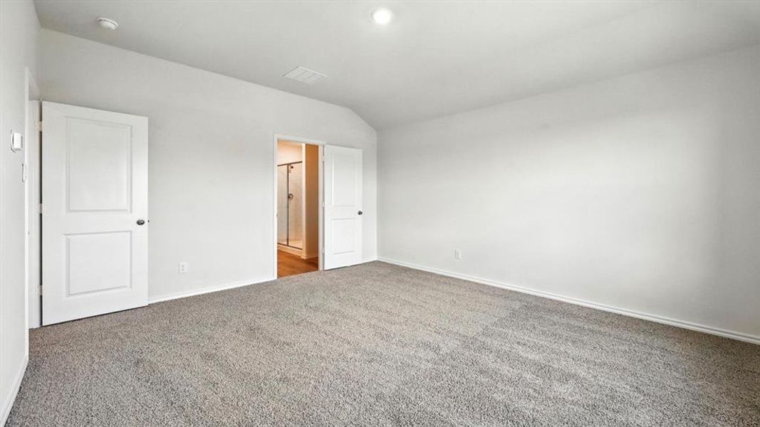 Unfurnished bedroom featuring carpet and vaulted ceiling