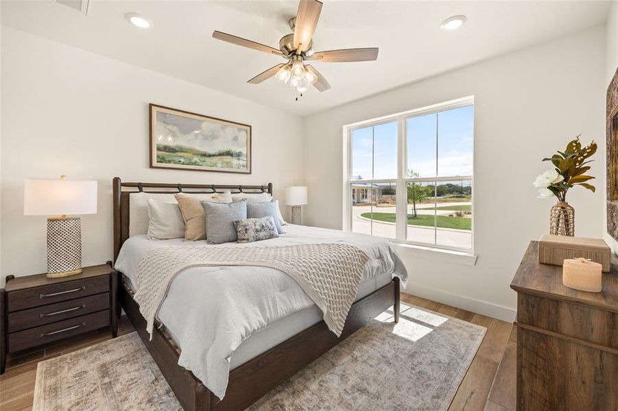 Bedroom featuring wood-finish flooring, a ceiling fan with integrated lighting, and recessed overhead lighting