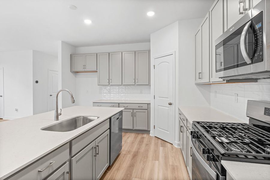 A kitchen with white cabinets.