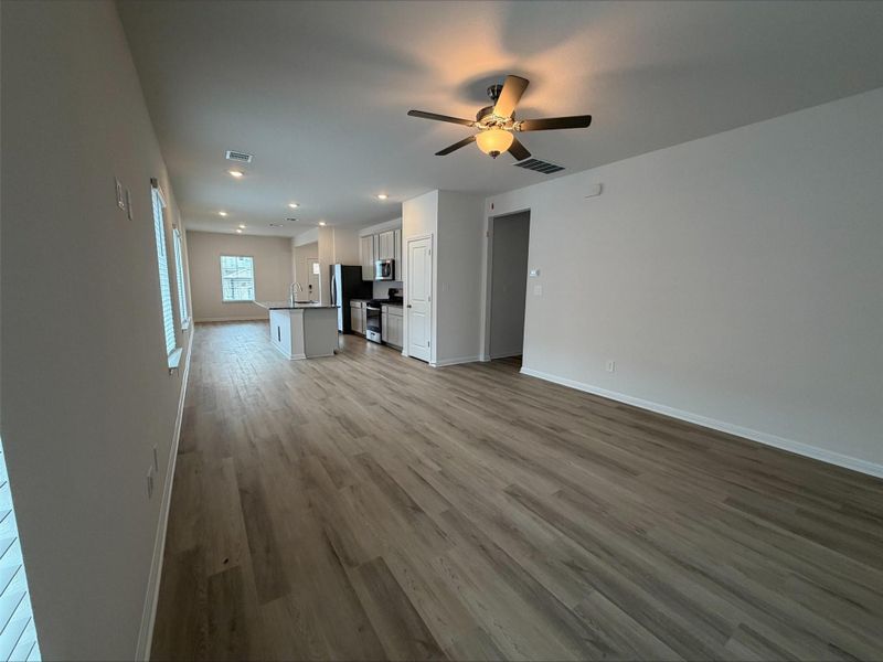 Unfurnished living room featuring light wood-type flooring, ceiling fan, and recessed lighting Unfurnished living room featuring light wood-type flooring, ceiling fan, and recessed lighting