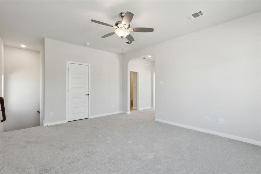 Unfurnished bedroom with ceiling fan and light colored carpet