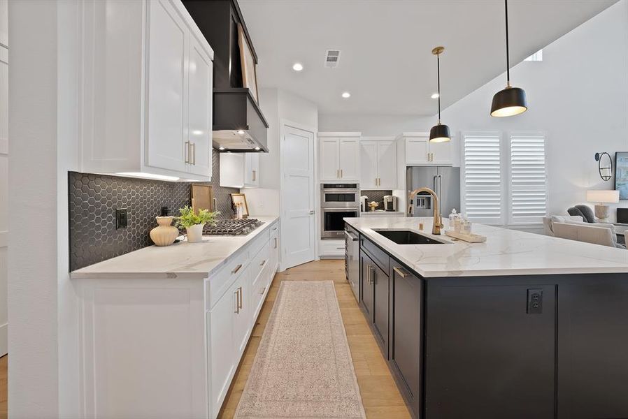 Modern kitchen featuring an expansive center island with a black base and a light-toned countertop Modern kitchen featuring an expansive center island with a black base and a light-toned countertop