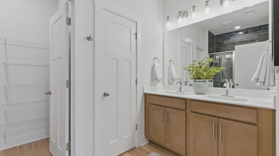Notable primary suite with dual vanities and walk-in shower in this prime Greenville villa at Pelham Crossing