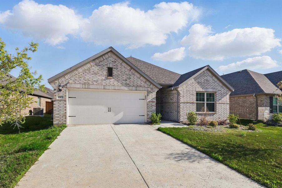 View of front of house with brick siding, a front lawn, driveway, and a shingled roof View of front of house with brick siding, a front lawn, driveway, and a shingled roof