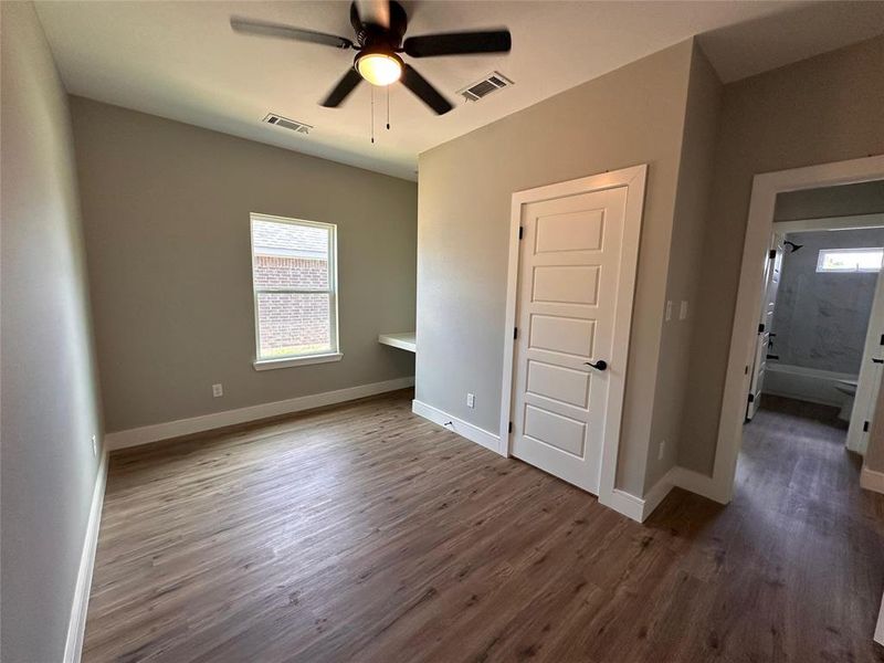 Secondary bedroom featuring built-in desk, closet, ceiling fan. LOTS OF LIGHT!