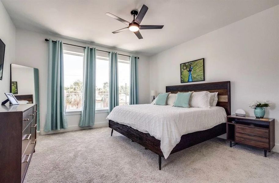 Bedroom with light carpet and a ceiling fan