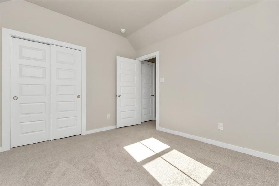 Secondary bedrooms showcase 5-panel doors adorned with modern hardware, large windows enhanced by privacy blinds, and spacious closets featuring sleek and contemporary finishes. Sample photo of completed home with similar floor plan. As-built interior colors and selections may vary.