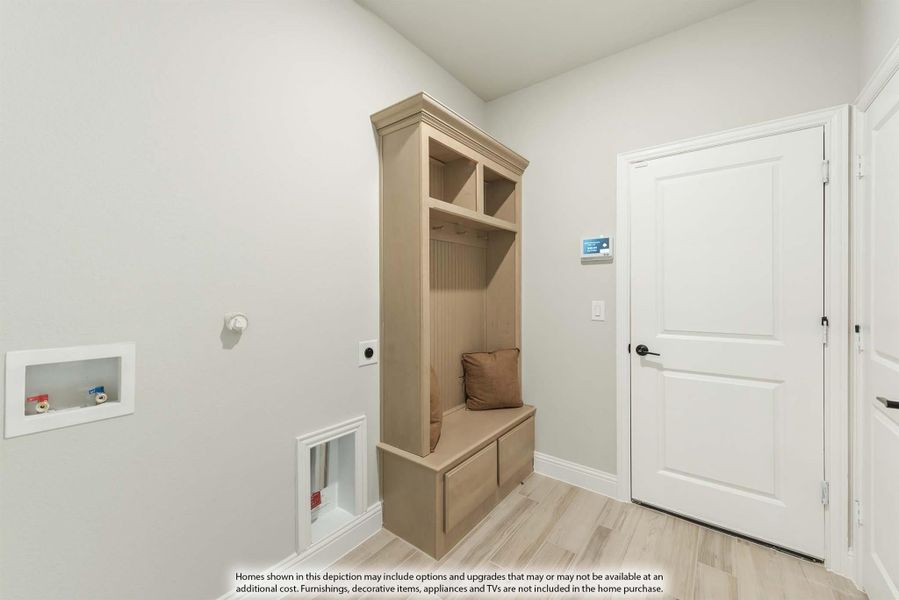 Mudroom with built-in wood locker unit featuring bench seat, cubbies, and storage drawers on light wood floors Mudroom with built-in wood locker unit featuring bench seat, cubbies, and storage drawers on light wood floors
