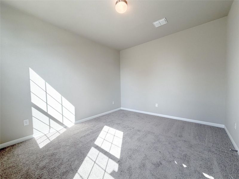 Carpeted room featuring light gray walls, white baseboards, and a flush mount ceiling light fixture