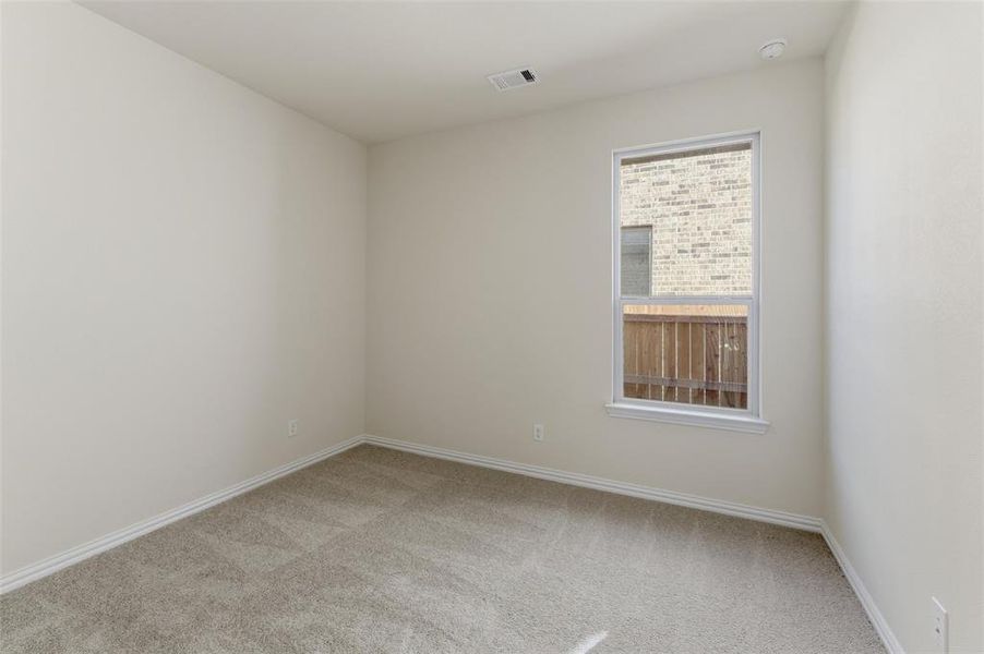Spare room with light carpet and baseboards