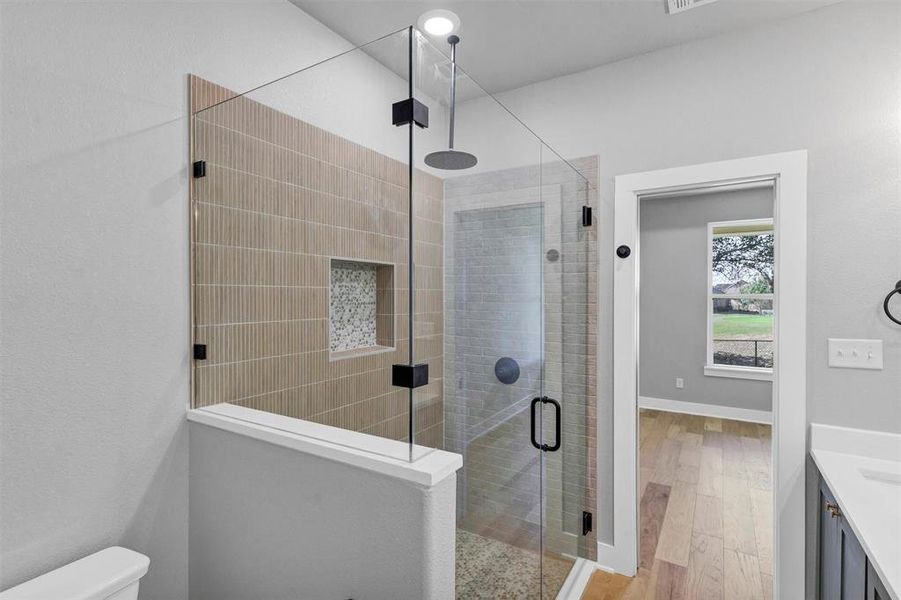 Full bath featuring vanity, a stall shower, and light wood-style flooring