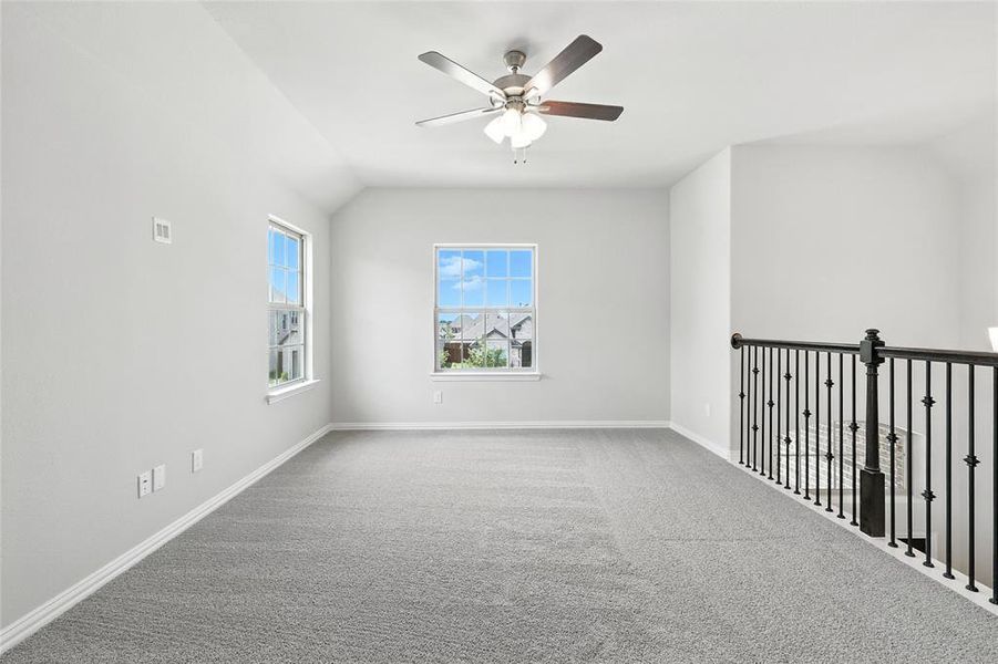 Carpeted spare room with ceiling fan and lofted ceiling Carpeted spare room with ceiling fan and lofted ceiling