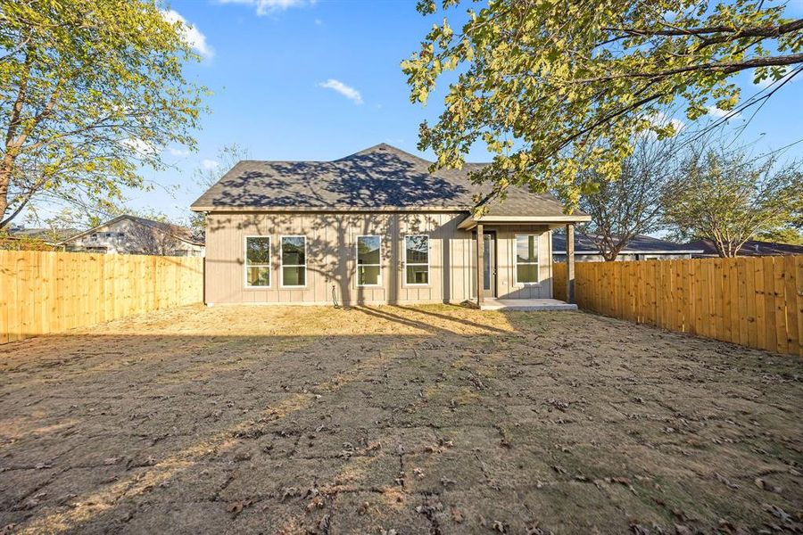 Rear view of property with roof with shingles, a patio area, and a fenced backyard Rear view of property with roof with shingles, a patio area, and a fenced backyard