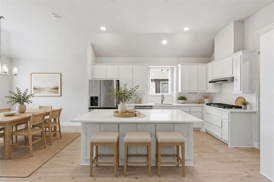 Spacious kitchen featuring a large center island, white cabinetry, and open-concept layout. Virtually staged.