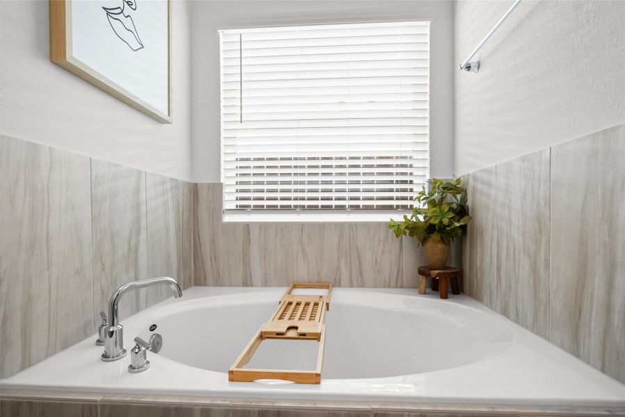 Your own private retreat! Unwind in the spacious soaking tub surrounded by soft, neutral finishes and natural light—the perfect place to relax at the end of the day.