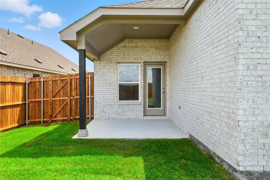 Property entrance with brick siding, a gate, and a patio area Property entrance with brick siding, a gate, and a patio area