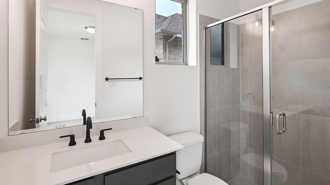 Full bathroom with a stall shower, vanity, and toilet