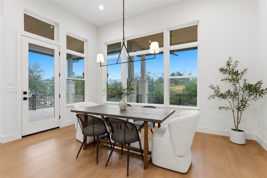 Dining room with light wood finished floors and healthy amount of natural light